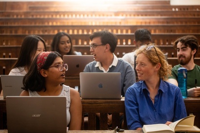 University of Cambridge students talking behind their computers during a lecture in the Student Services Centre old lecture hall.